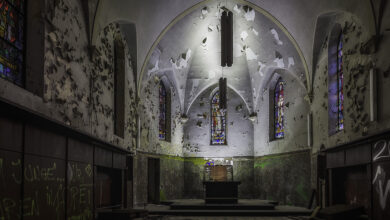 Verlassene Kirche mit Graffiti und bröckelndem Putz.